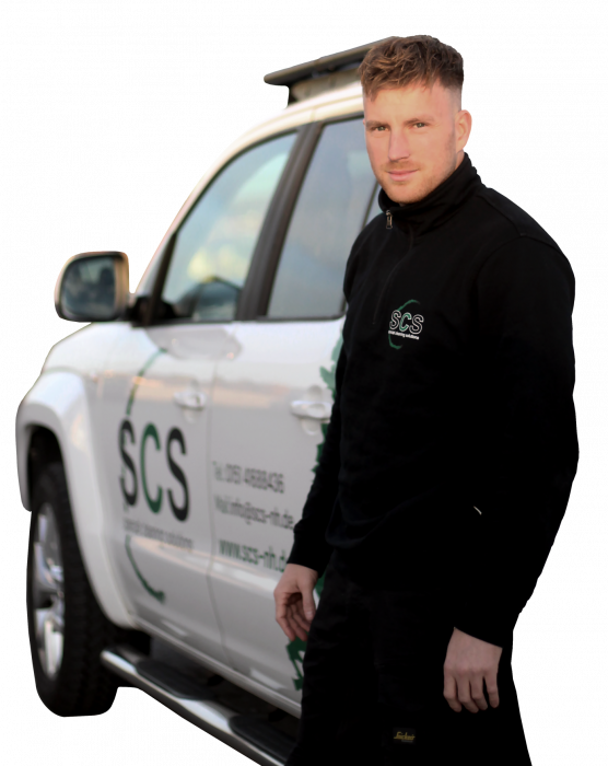 Freigestelltes Portrait von Nick Heyden in SCS Firmenkleidung, überkreuzte Arme