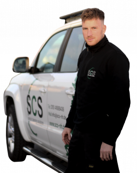 Freigestelltes Portrait von Nick Heyden in SCS Firmenkleidung, überkreuzte Arme